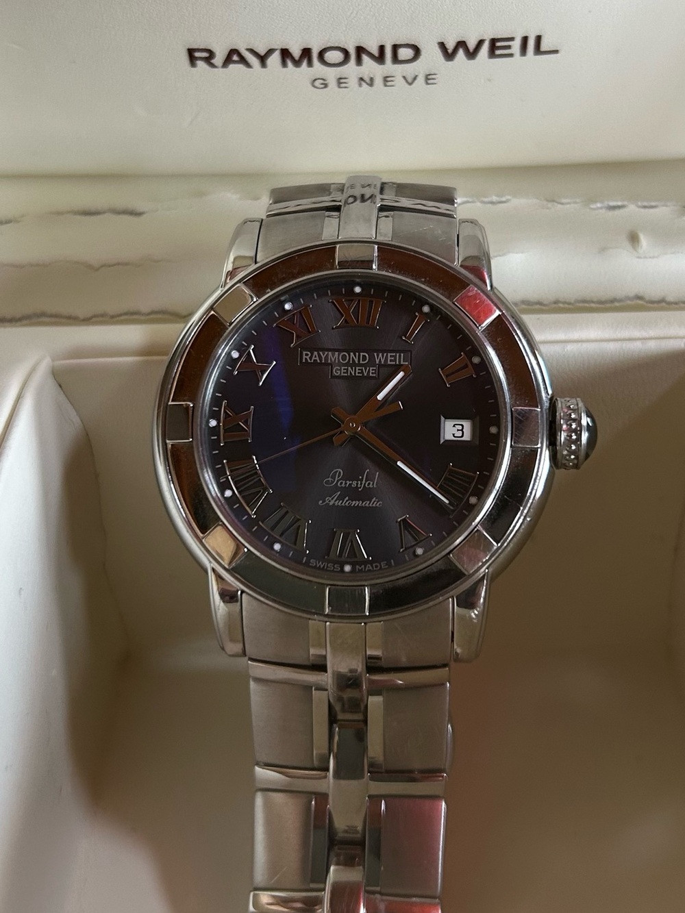 Raymond Weil Geneve silver watch with dark grey face.